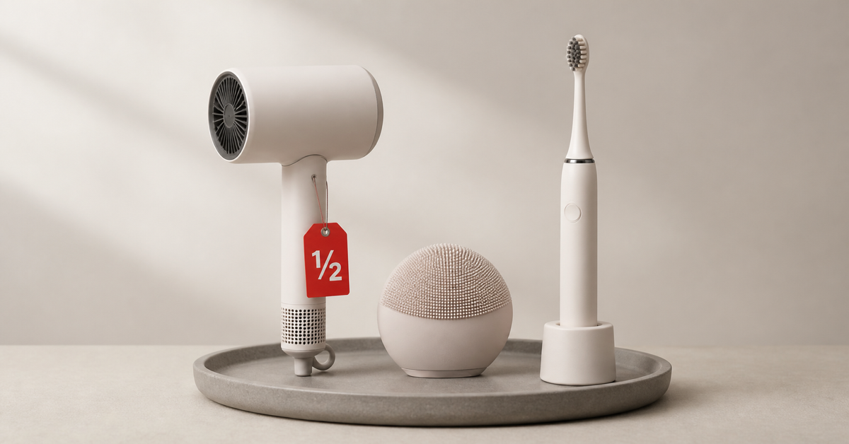 Hair dryer, facial cleansing device and electric toothbrush on a tray with a red half-price tag — buying open-box beauty devices safely