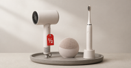 Hair dryer, facial cleansing device and electric toothbrush on a tray with a red half-price tag — buying open-box beauty devices safely