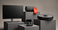 Open-box electronics on grey plinths with red half-price tag
