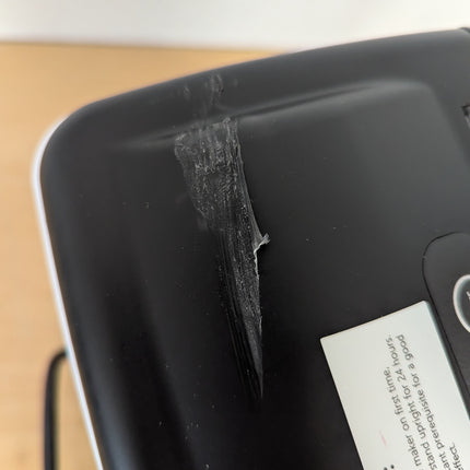 Actual unit: scuffed, raised patch in the plastic of the top cover near the back left corner