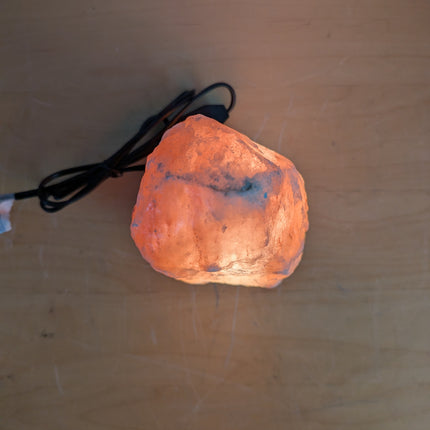 Actual unit: Himalayan salt lamp lit on its wooden base